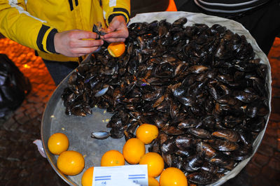 Midsection of men by oyster stall at night