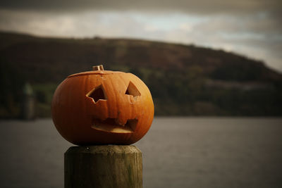 Close-up of pumpkin on wooden post during halloween