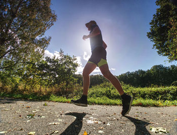 Full length of woman on footpath by trees against sky