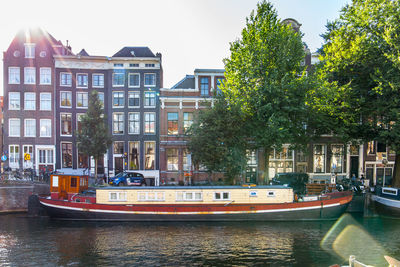 Boats in canal amidst buildings in city