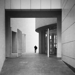 Rear view of man walking in corridor of building
