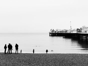People on beach against clear sky