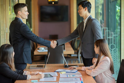 Businessmen doing handshake in meeting