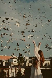 Low angle view of woman flying birds