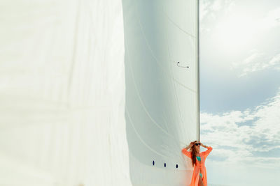 Young woman standing on boat against sky