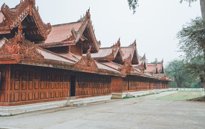 Temple by building against clear sky