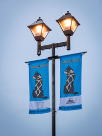 Close-up of illuminated lamp against blue sky