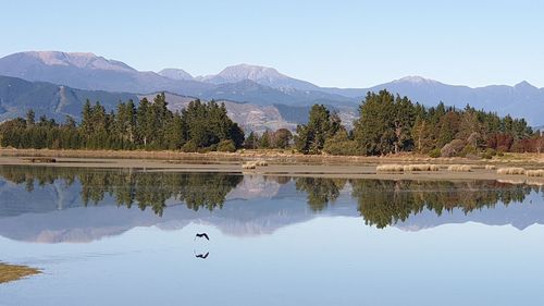 Scenic view of lake and mountains against clear sky