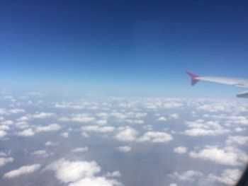 Cropped image of airplane flying over clouds