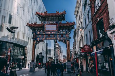 People walking on street amidst buildings in city