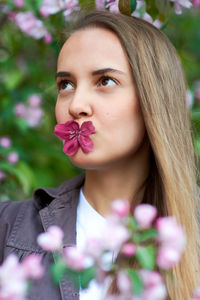 Close-up portrait of woman with pink flower