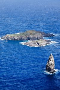 Rock formation in sea against blue sky