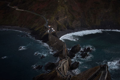 Aerial view of road on mountain ridge amidst sea