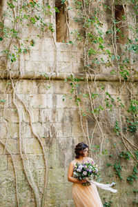 Woman standing by tree in forest