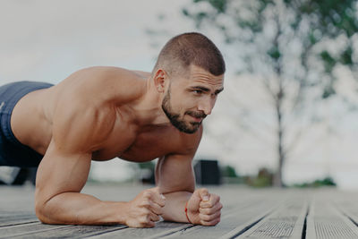 Full length of shirtless man looking at camera