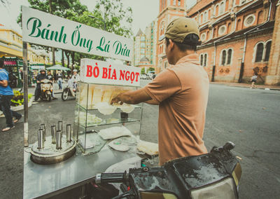 Rear view of man standing on street in city