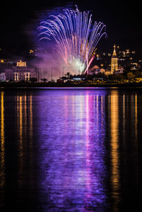 Firework display over river at night