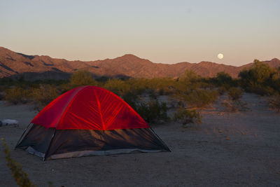 Tent on mountain against sky at dusk