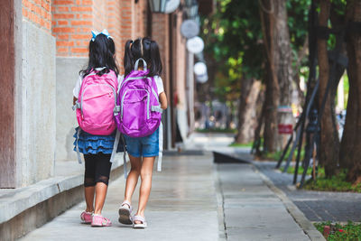 Rear view of women walking on footpath