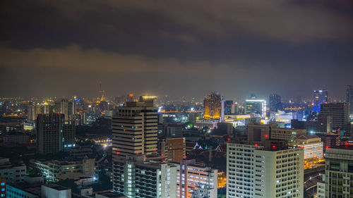 Illuminated buildings in city against sky