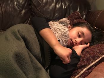 Close-up of young woman sleeping on bed at home