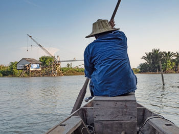 Rear view of man in boat against clear sky