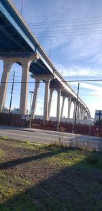 Low angle view of bridge over river against sky