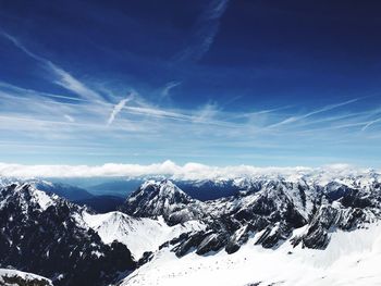 Scenic view of snowcapped mountains against blue sky