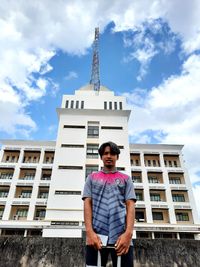 Portrait of young man standing against building