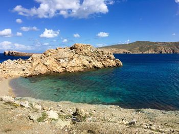 Scenic view of sea and mountains against blue sky