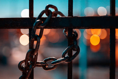 Close-up of chain hanging on metal fence