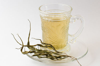 Close-up of glass of tea against white background