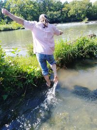 Rear view of woman standing by lake