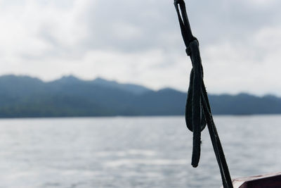 Close-up of rope on lake against sky