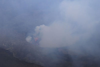 Smoke emitting from volcanic mountain against sky