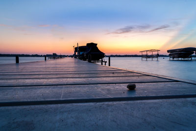 Pier over sea against sky at sunset