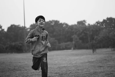 Boy running on grassy field
