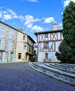 Houses by street in town against sky