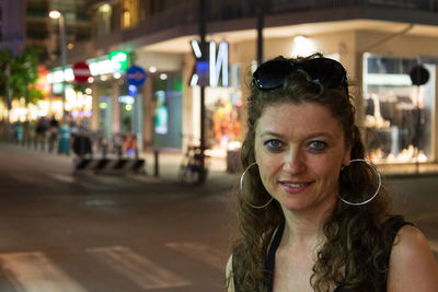 Portrait of smiling woman standing on street in city