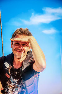 Portrait of smiling man standing against sky