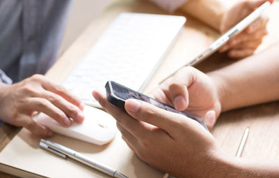 Close-up of business colleagues working at desk in office