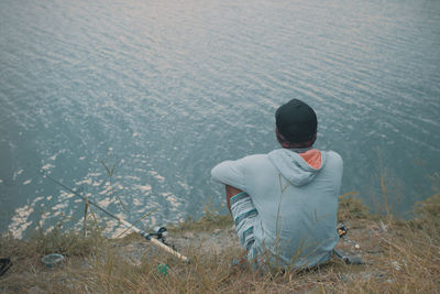 Rear view of man sitting on land