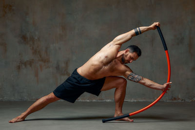 Full length of man exercising against wall