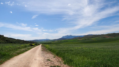 Dirt road along countryside landscape