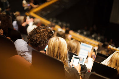 Rear view of people sitting on floor