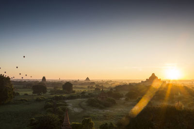 Temple on landscape against sky during sunset