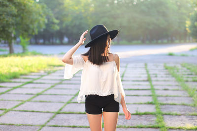 Rear view of woman wearing hat standing outdoors