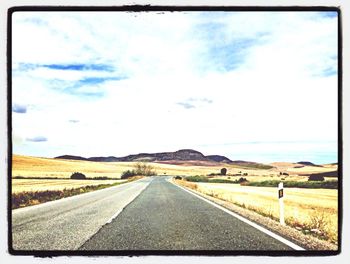 Empty road against cloudy sky