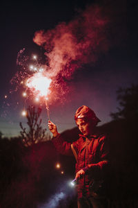 Young boy with sparkles light by night