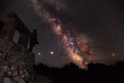 Silhouette man standing against star field at night